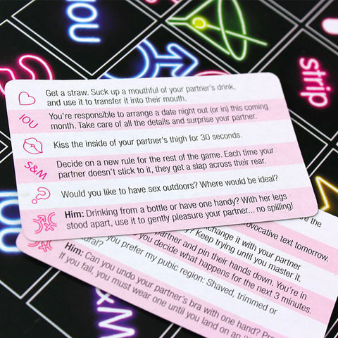  A hand drawing a card from the Sex Marks The Spot Game deck with playful and sexy illustrations